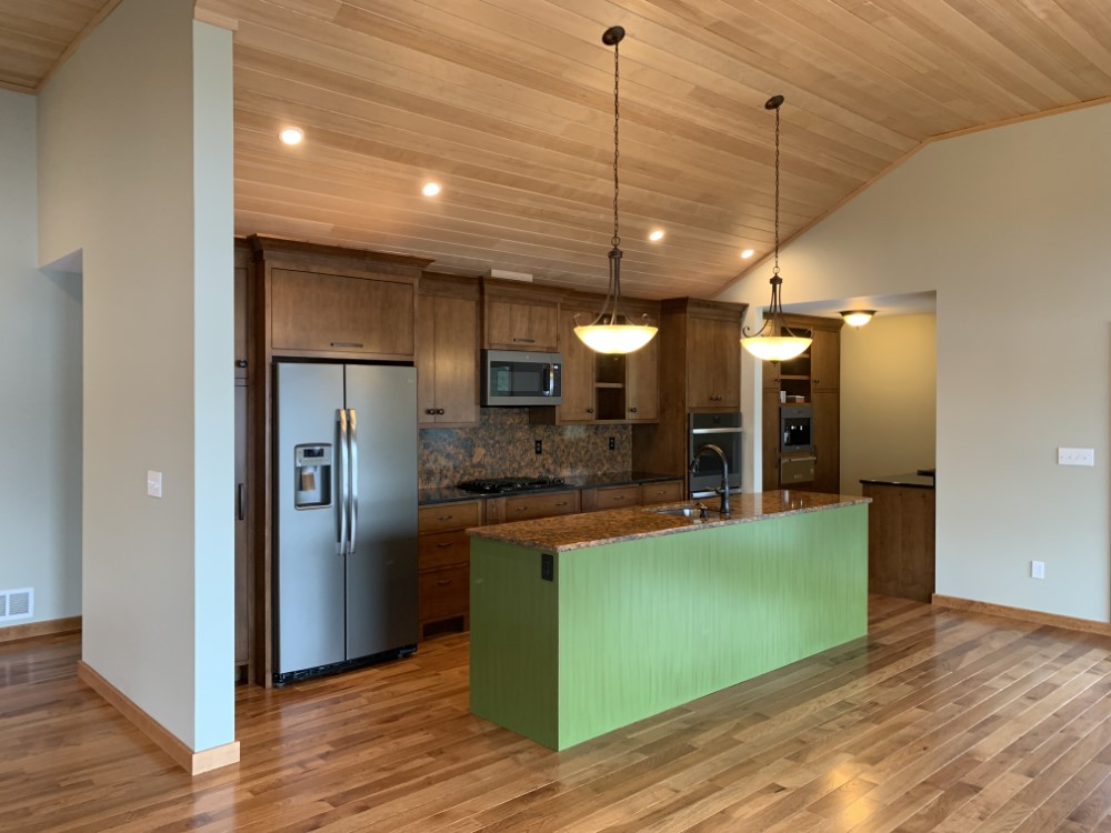 Custom granite kitchen with island counter open concept to hardwood floor living room